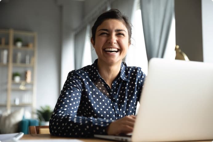 a woman smiling while sitting at a desk