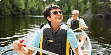 an older couple padding a canoe