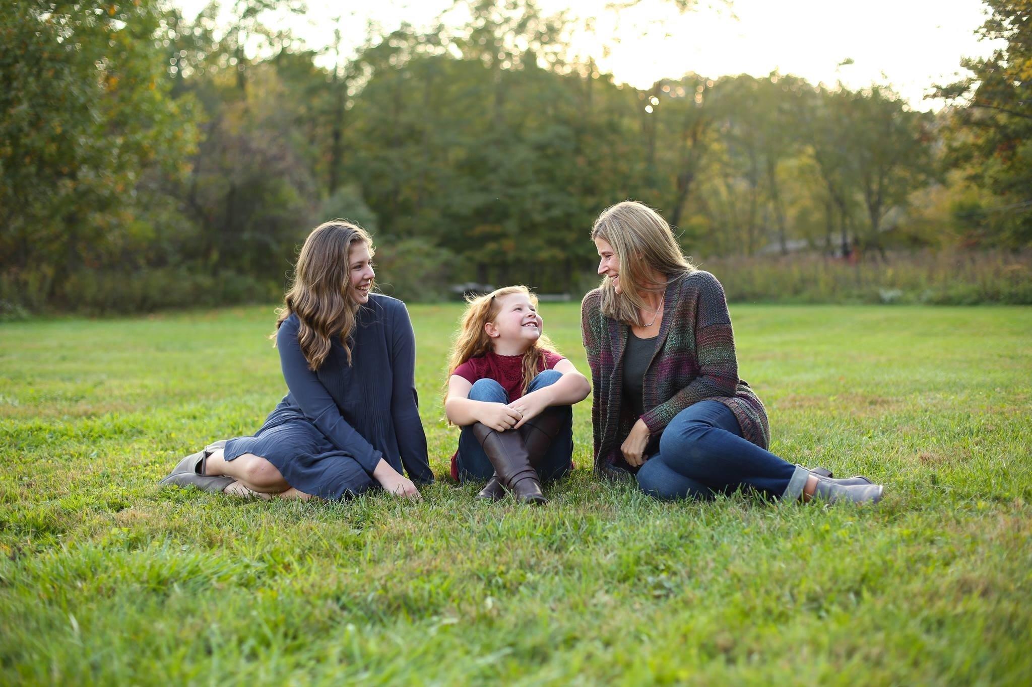 a group of women sitting on the grass