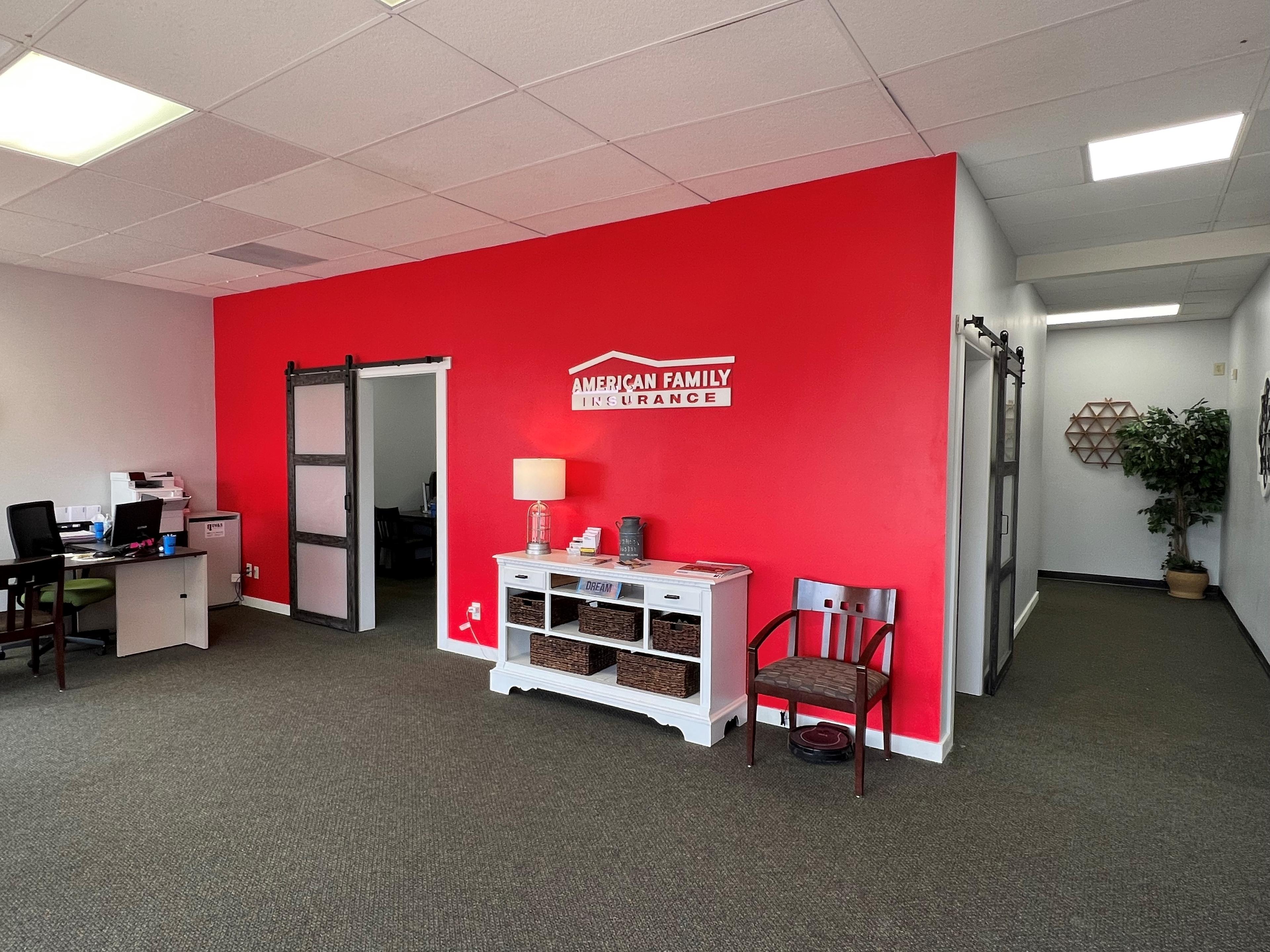 a room with a red wall and a bed and a desk