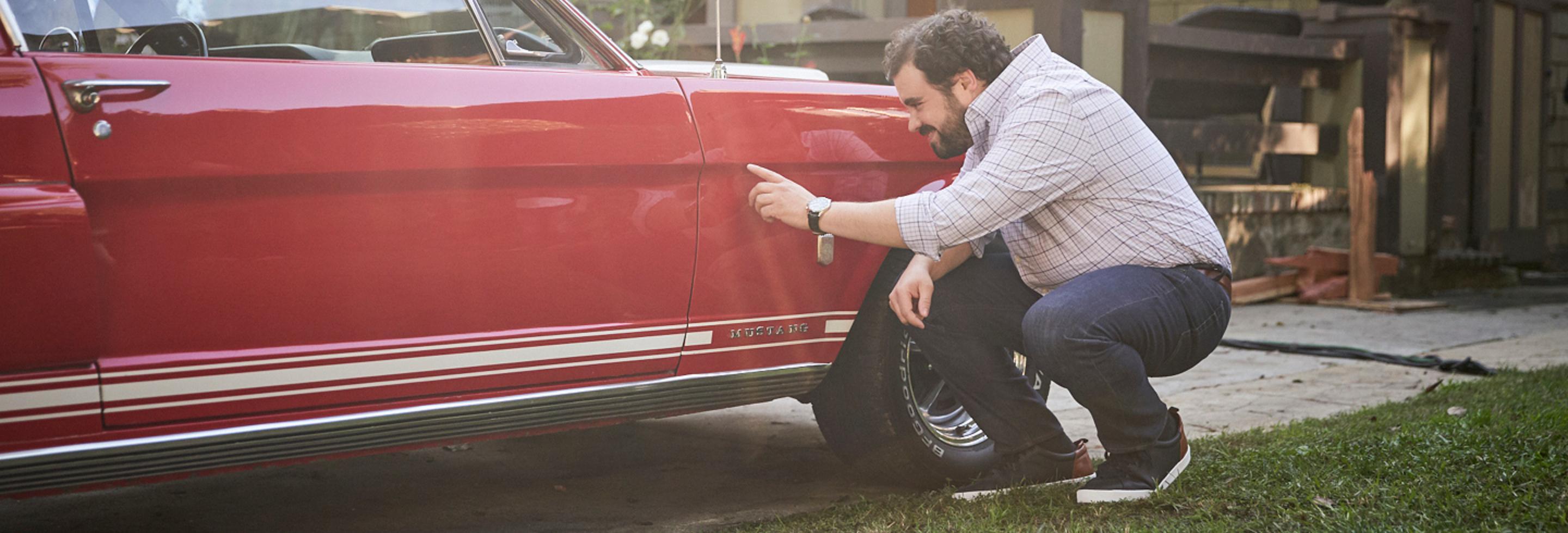 a man touching a red car