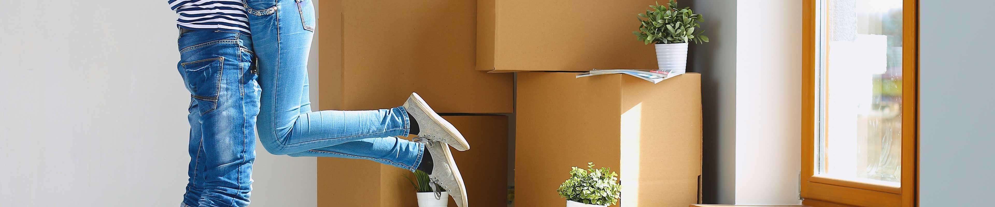 Couple embracing surrounded by packing boxes