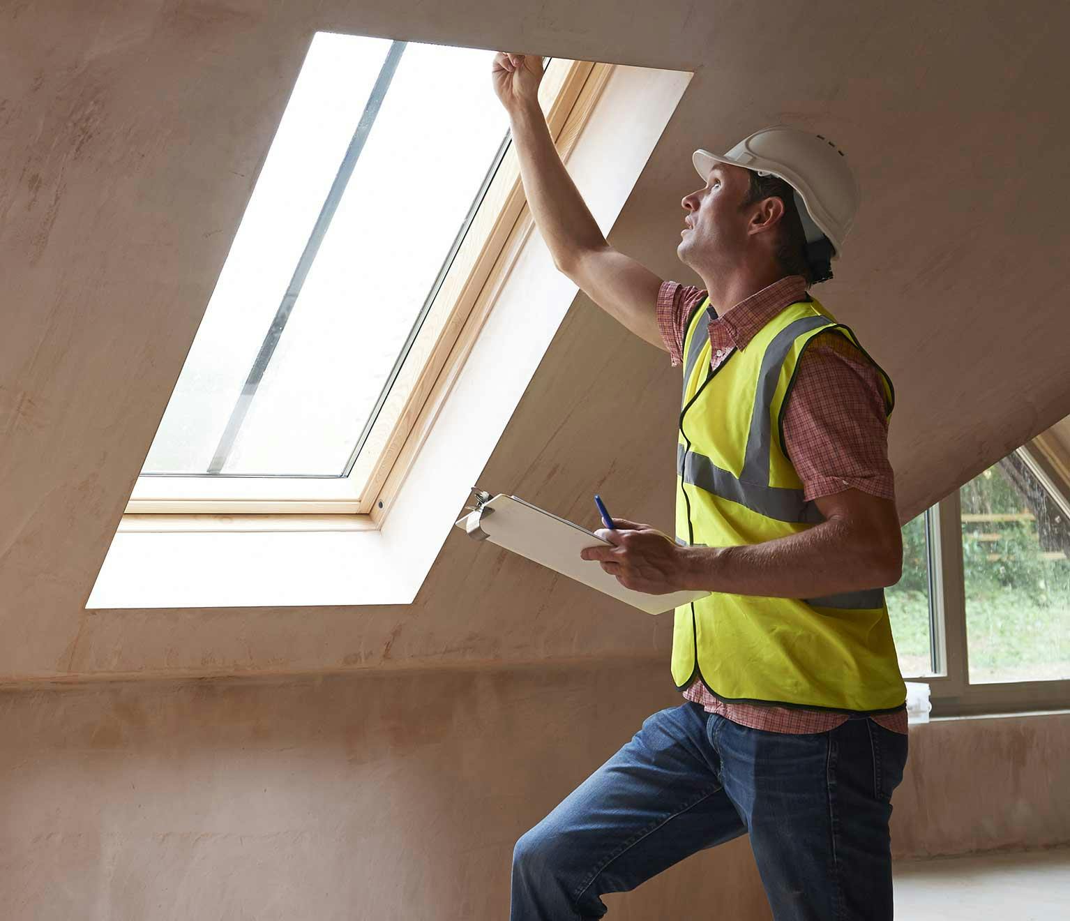 Image of a home inspector checking out a skylight window.