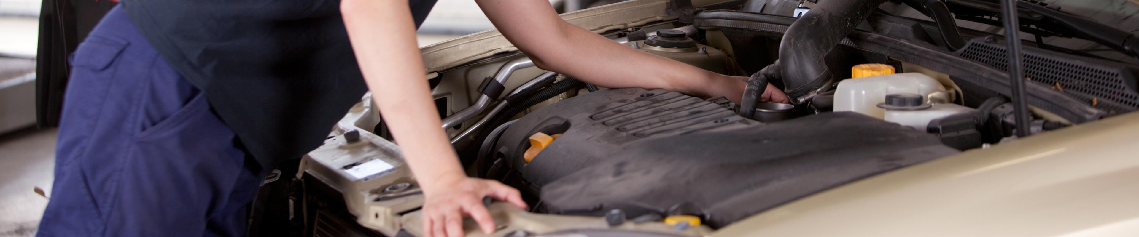 someone inspecting the engine of a car