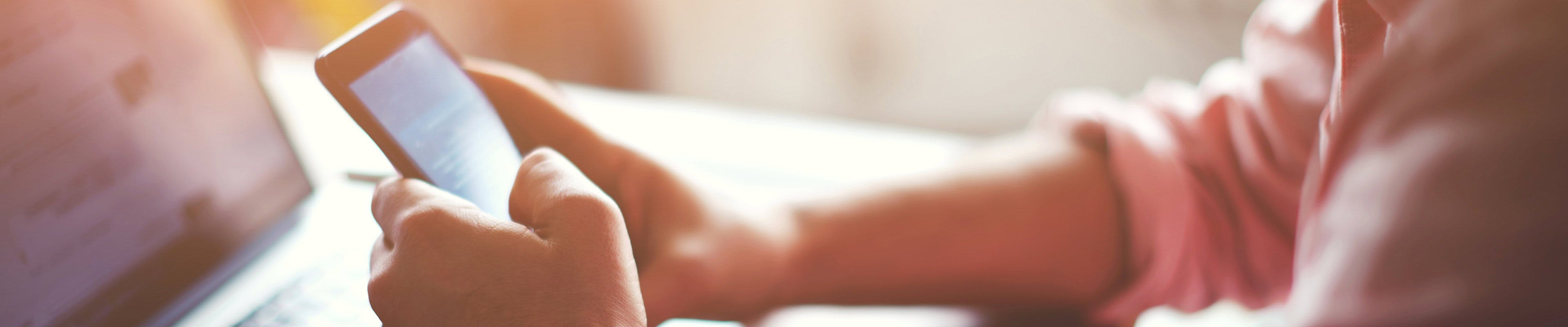 Man browsing internet on phone and laptop