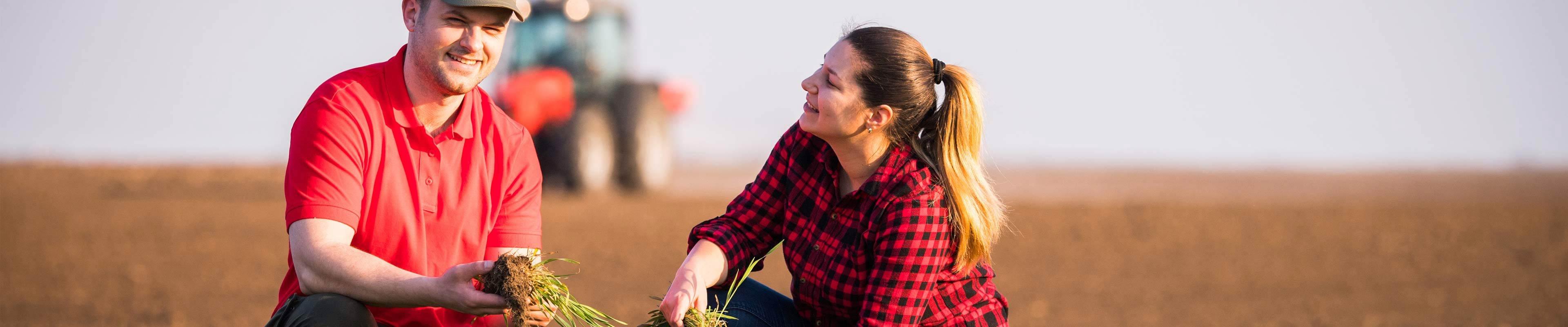 Young man and woman working  in their farm field.