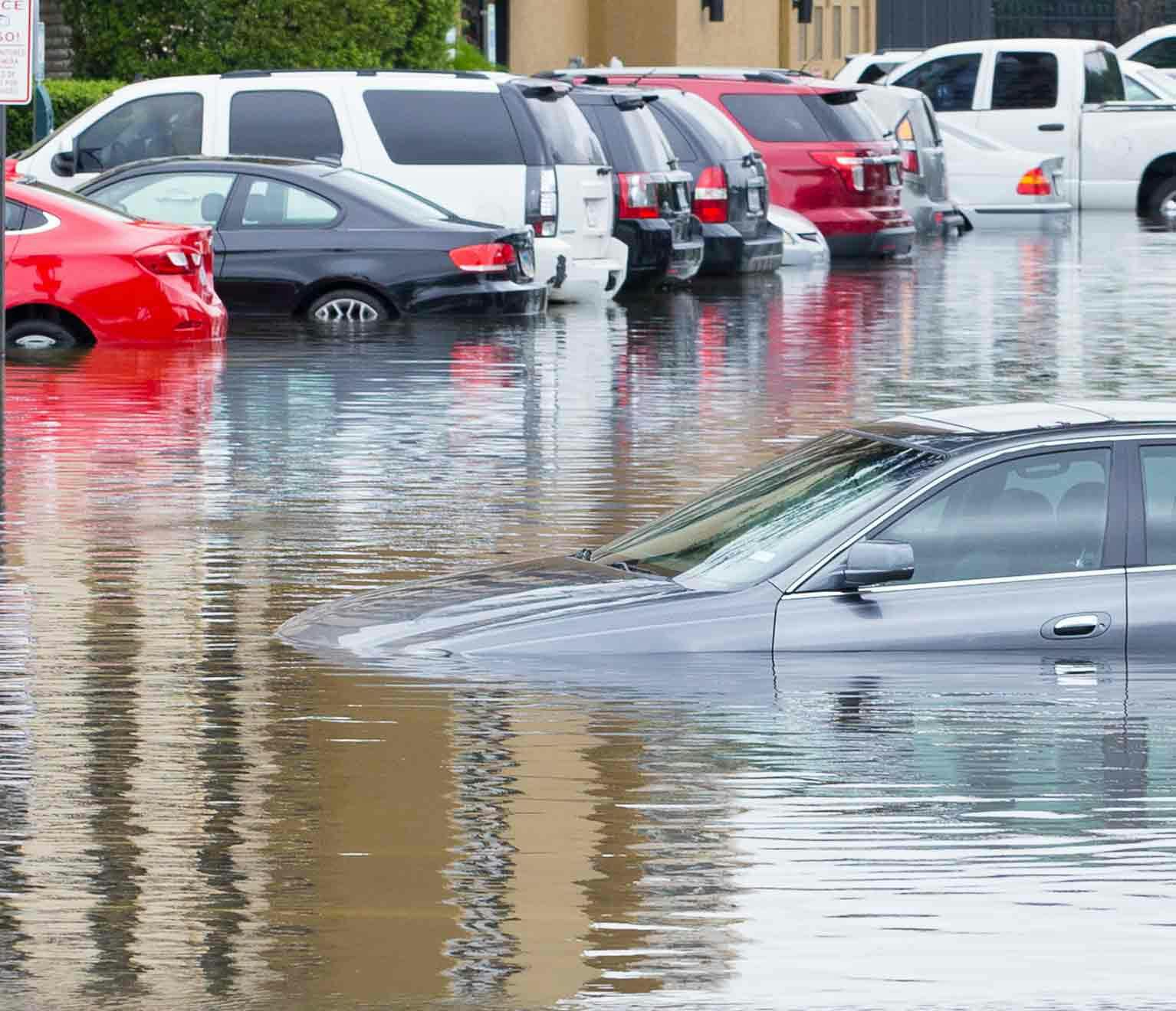 Image of parked cars flooded in a lot.